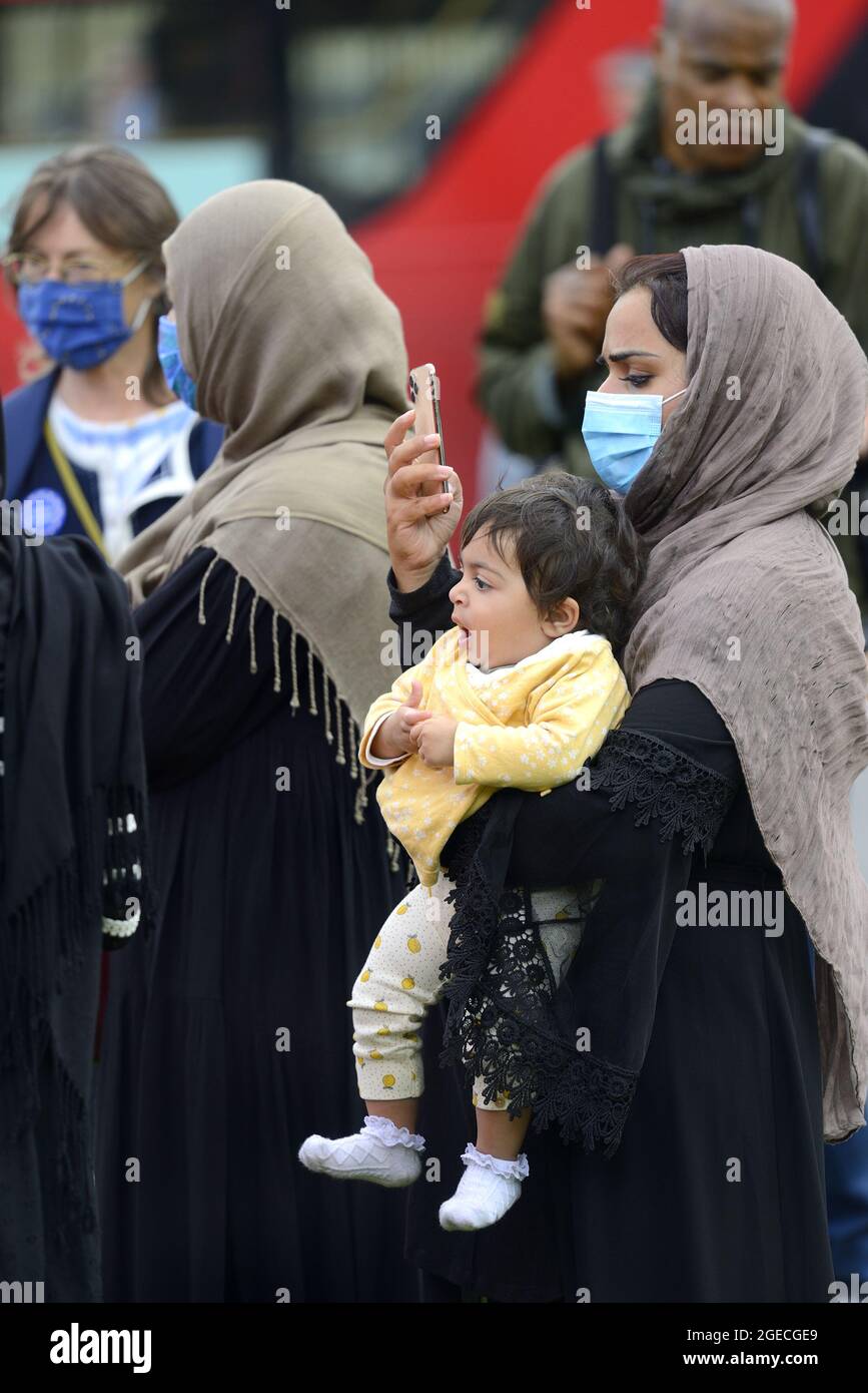 London, England, Großbritannien. Afghanische Frau mit ihrem kleinen Kind, auf ihrem Mobiltelefon, in Westminster, während die Übernahme Afghanistans durch die Taliban in Par diskutiert wird Stockfoto