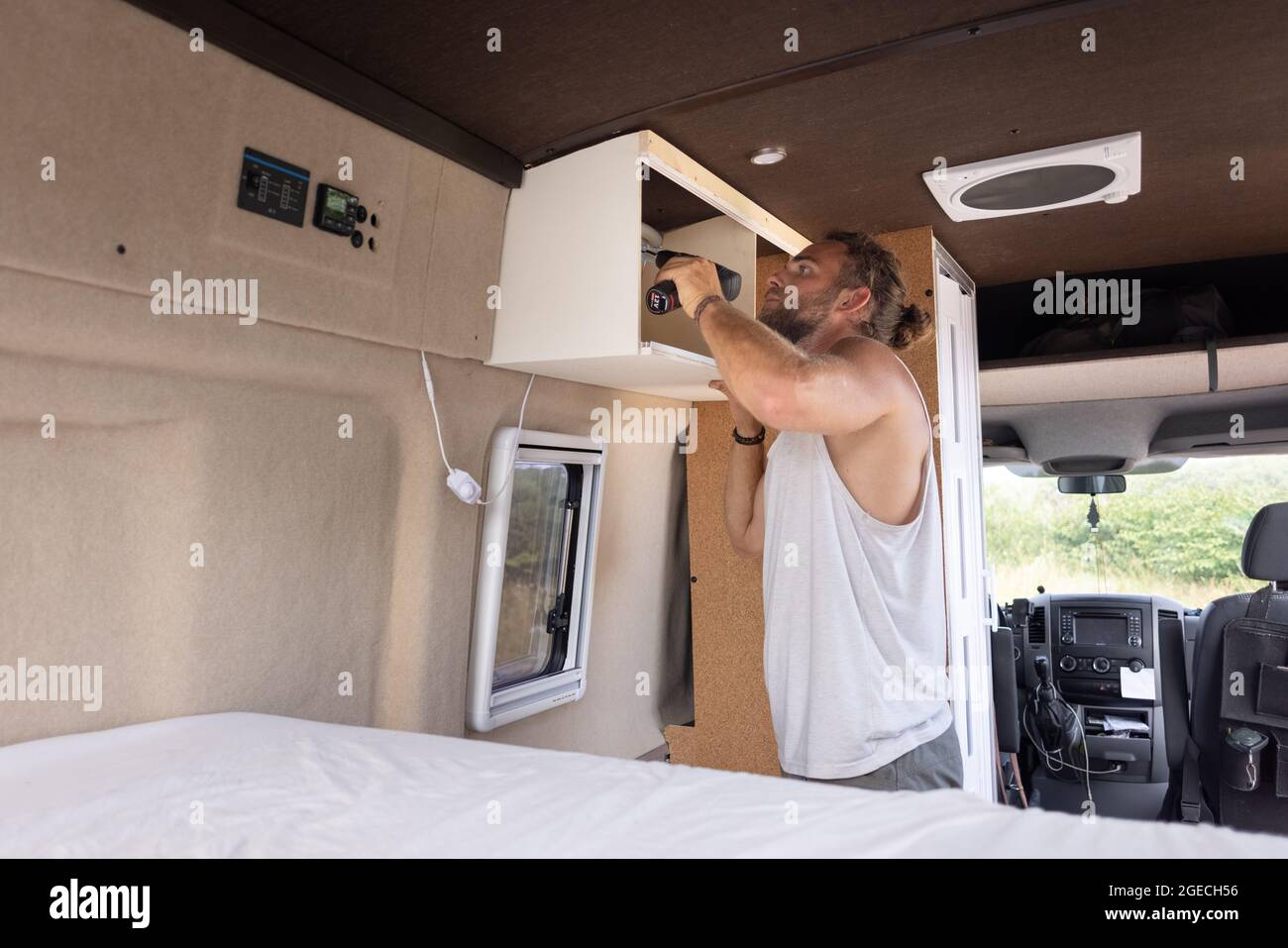 Mann, der einen kleinen Schrank in einen Wohnwagen einzieht Stockfoto