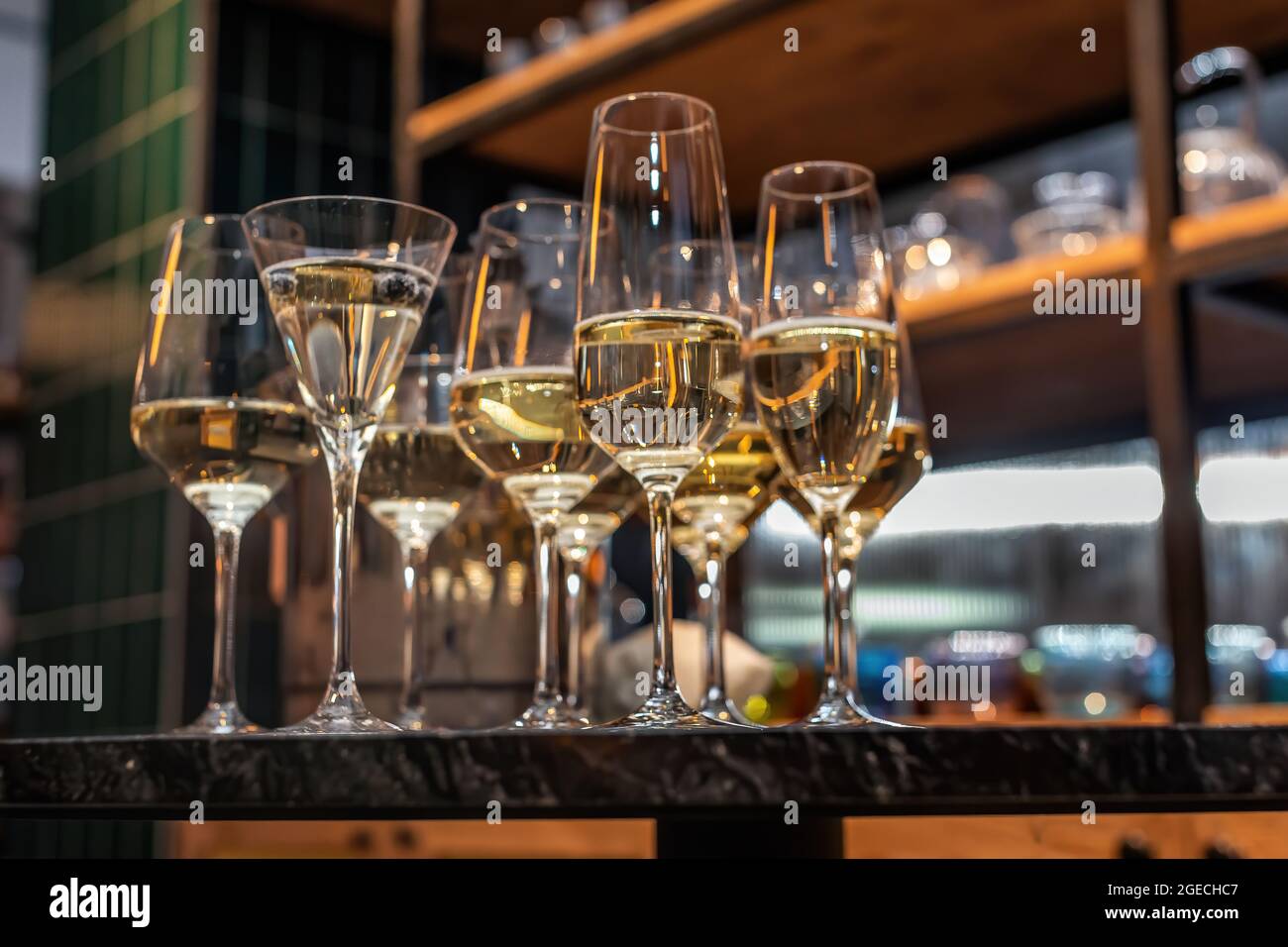 Viele verschiedene Weingläser auf dem Tisch. Stillleben von Gläsern mit alkoholischem Getränk auf der Vitrine. Stockfoto
