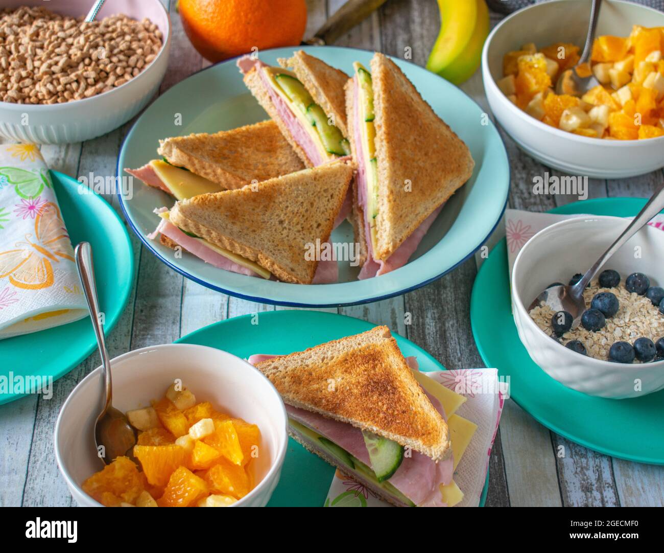 Häusliches Leben. Ein Tisch mit gesunden Frühstückssnacks wie Sandwiches, Müsli und Obst Stockfoto