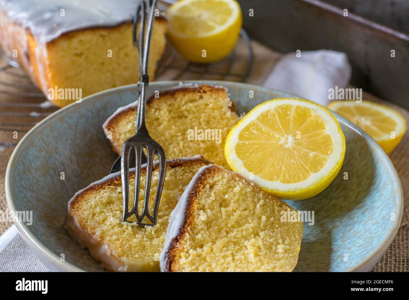 Stücke von frisch gebackenen Zitronenkuchen auf rustikalem und hölzernen Tischhintergrund mit Kuchengabel Stockfoto