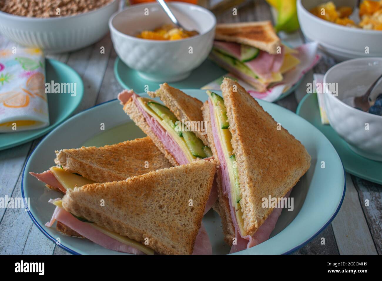 Getoastete Sandwiches mit Obst und Müsli auf einem Frühstückstisch zu Hause Stockfoto