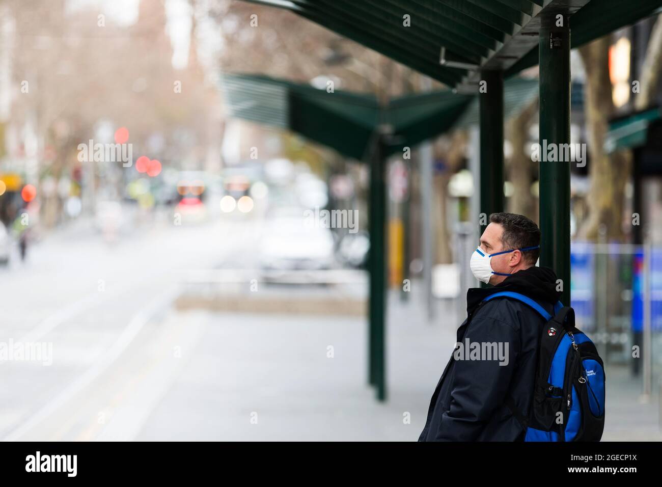 Melbourne, Australien, 3. August 2020. Ein Mann mit Gesichtsmask wartet während der COVID-19 in Melbourne, Australien, an einer leeren Straßenbahnhaltestelle. Während Melbourne seinen ersten Tag der Beschränkungen der Stufe 4 erlebt, sowie eine Ausgangssperre von 20:00 bis 5:00 Uhr, kündigte Premier Daniel Andrews heute den Plan für die Stilllegung für alle außer den wichtigsten Unternehmen für mindestens die nächsten 6 Wochen an. Victoria verzeichnete weitere 429 COVID-19-Fälle und 13 weitere Todesfälle, was die Gesamtzahl der aktiven Fälle in den Bundesstaaten auf 6,489 brachte. Kredit: Dave Hewison/Speed Media/Alamy Live Nachrichten Stockfoto