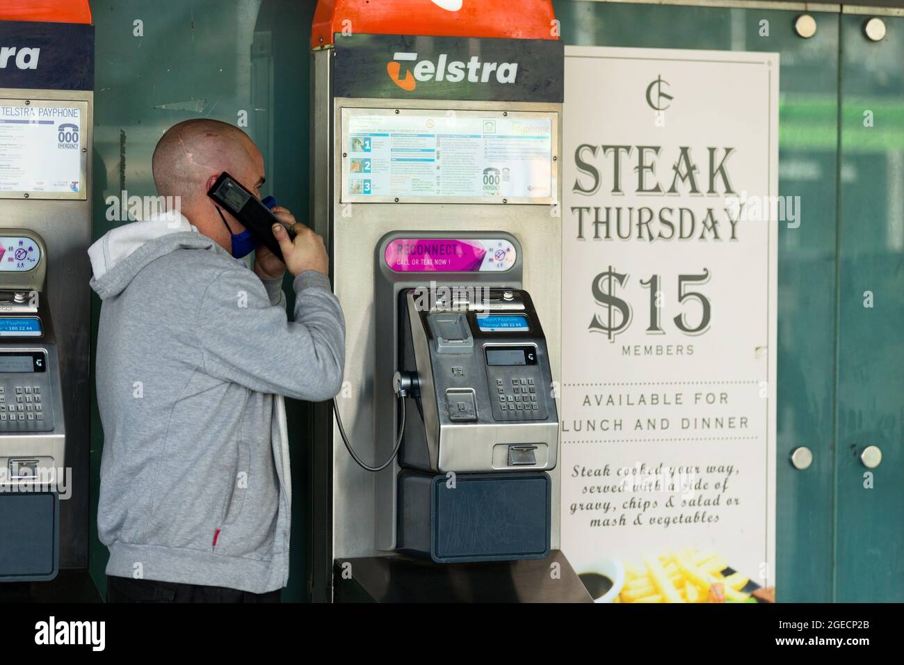 Melbourne, Australien, 3. August 2020. Ein Mann spricht auf einem öffentlichen Telefon an der Flinders Street Station während der COVID-19 in Melbourne, Australien. Während Melbourne seinen ersten Tag der Beschränkungen der Stufe 4 erlebt, sowie eine Ausgangssperre von 20:00 bis 5:00 Uhr, kündigte Premier Daniel Andrews heute den Plan für die Stilllegung für alle außer den wichtigsten Unternehmen für mindestens die nächsten 6 Wochen an. Victoria verzeichnete weitere 429 COVID-19-Fälle und 13 weitere Todesfälle, was die Gesamtzahl der aktiven Fälle in den Bundesstaaten auf 6,489 brachte. Kredit: Dave Hewison/Speed Media/Alamy Live Nachrichten Stockfoto