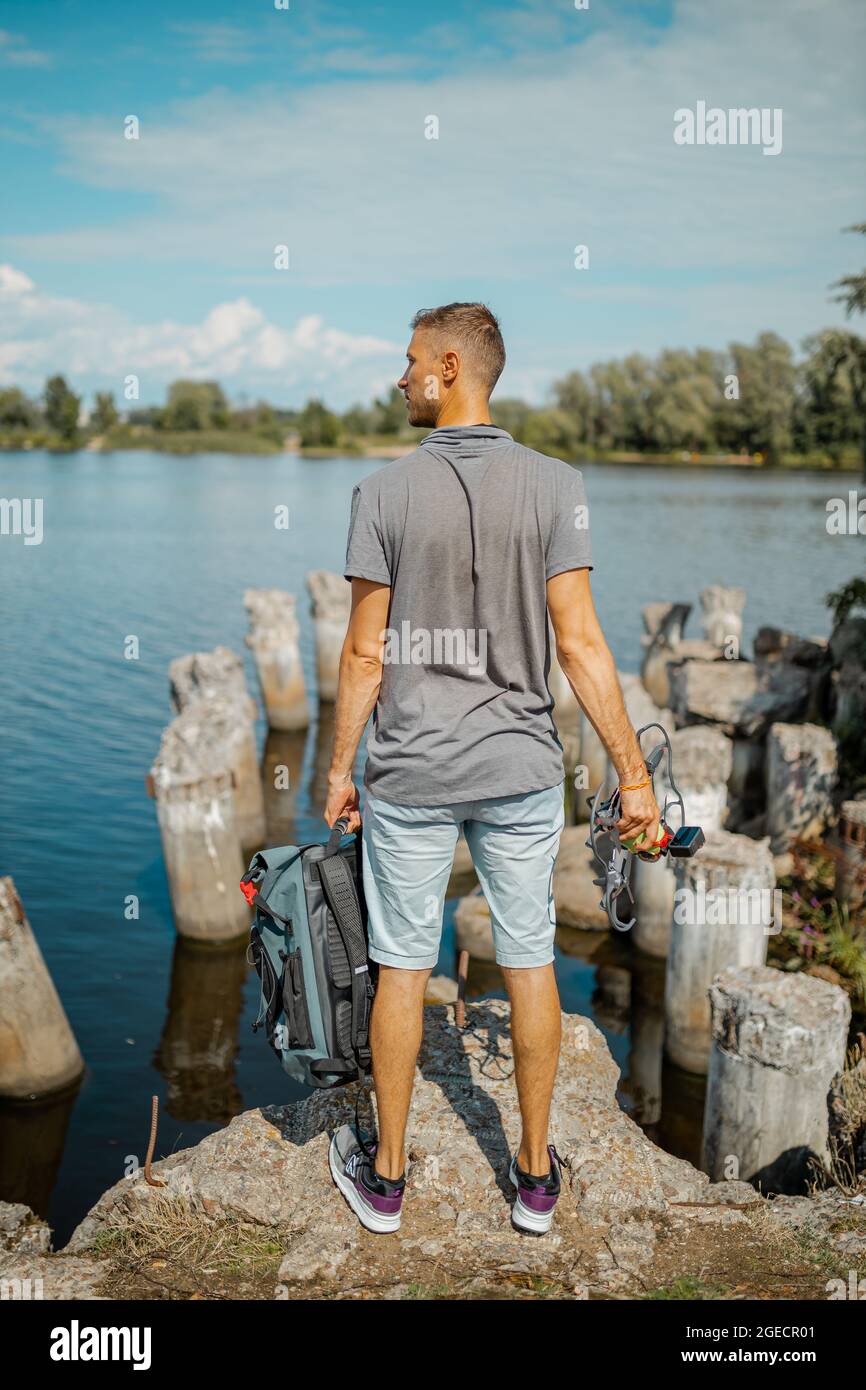 Mann mit Rucksack bereit, eine lange Straße zu gehen und die Welt zu erkunden. Stockfoto