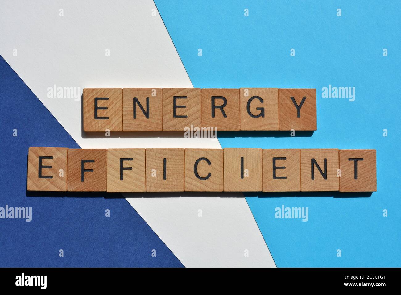 Energieeffizient, Wörter in Holzbuchstaben isoliert auf blauem und weißem Hintergrund als Banner-Überschrift Stockfoto