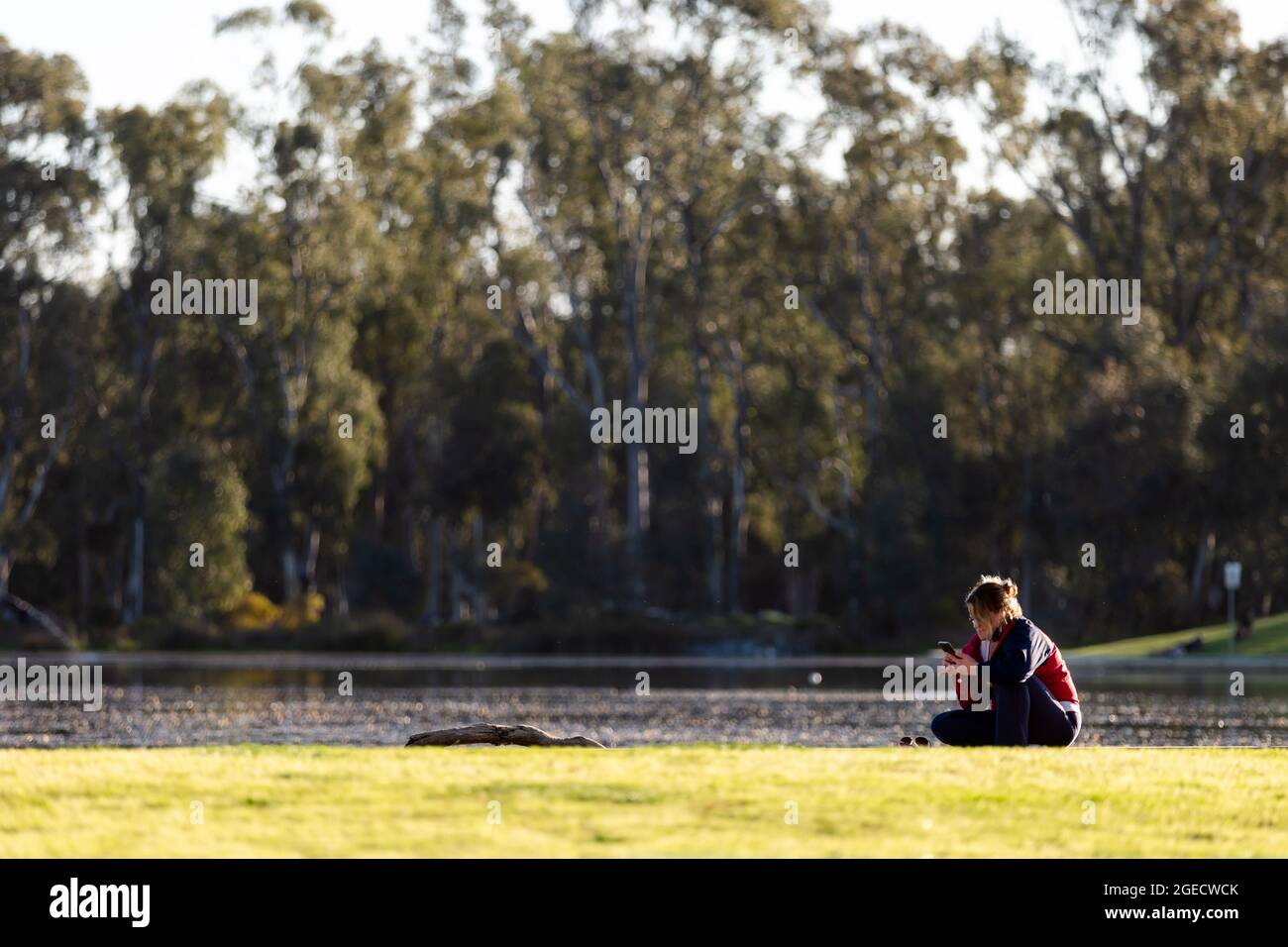 Shepparton, Australien, 16. September 2020. Eine Frau sitzt am Goulburn River während der COVID-19 in Melbourne, Australien. Premier Daniel Andrews gab gestern bekannt, dass die Region Victoria zu Schritt 3 der Roadmap übergehen wird. Für Shepparton, im Zentrum von Victoria, scheint dies zu wenig, zu spät zu sein. Kredit: Dave Hewison/Speed Media/Alamy Live Nachrichten Stockfoto