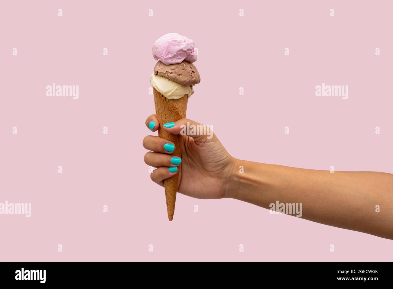 Die Hand der Frau hält ein Eis auf einem rosa Hintergrund Stockfoto