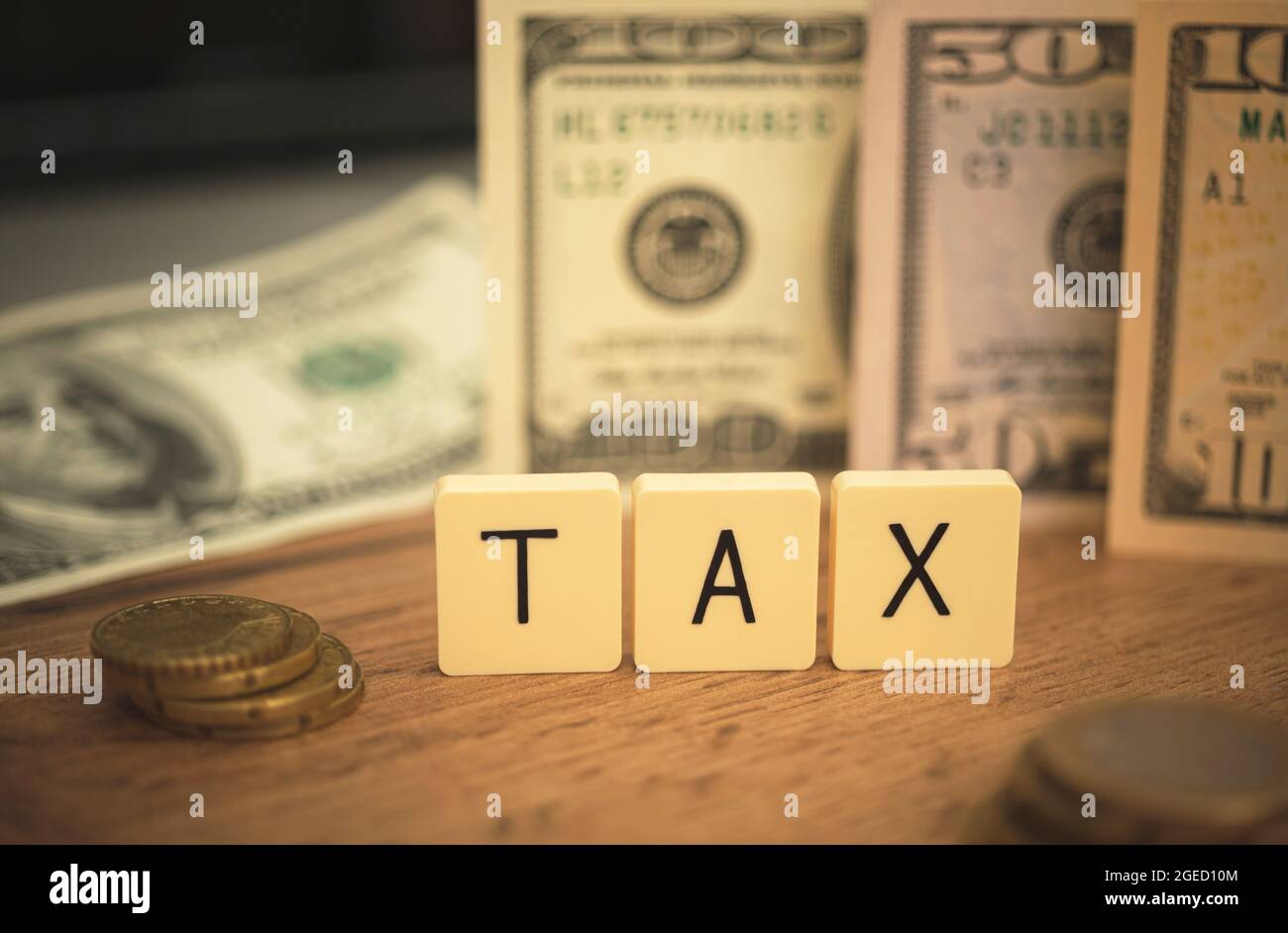 Konzept der Senkung DER STEUERN, Vermeidung. Kosten und Aufwendungen des Unternehmens, Steuern. Zahlen Sie den Hintergrund der Schulden mit Desktop- und US-Dollar-Scheinen aus Stockfoto
