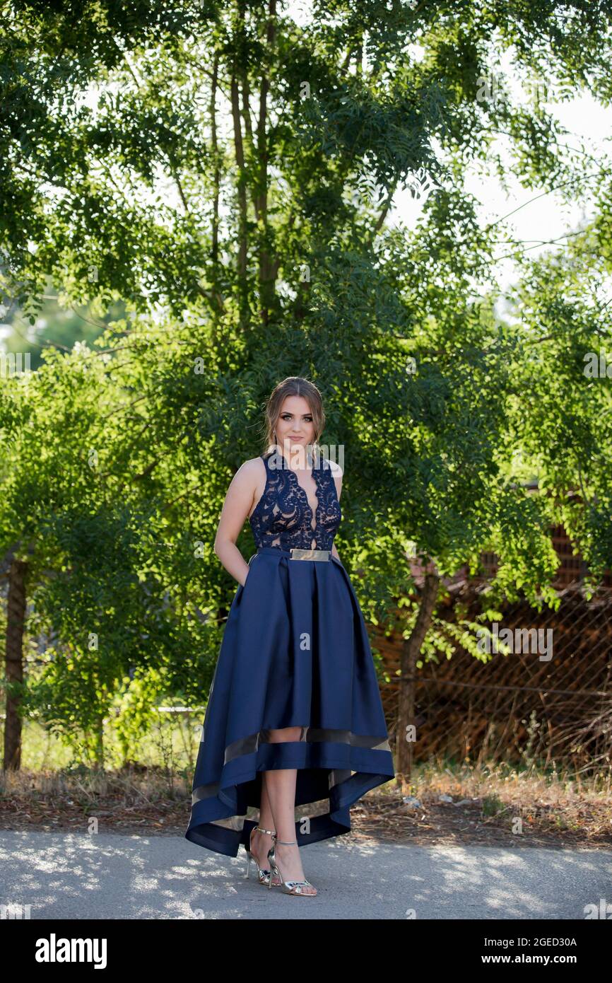 Im Park posiert die hübsche bosnische Frau, die ein elegantes blaues Kleid  trägt Stockfotografie - Alamy