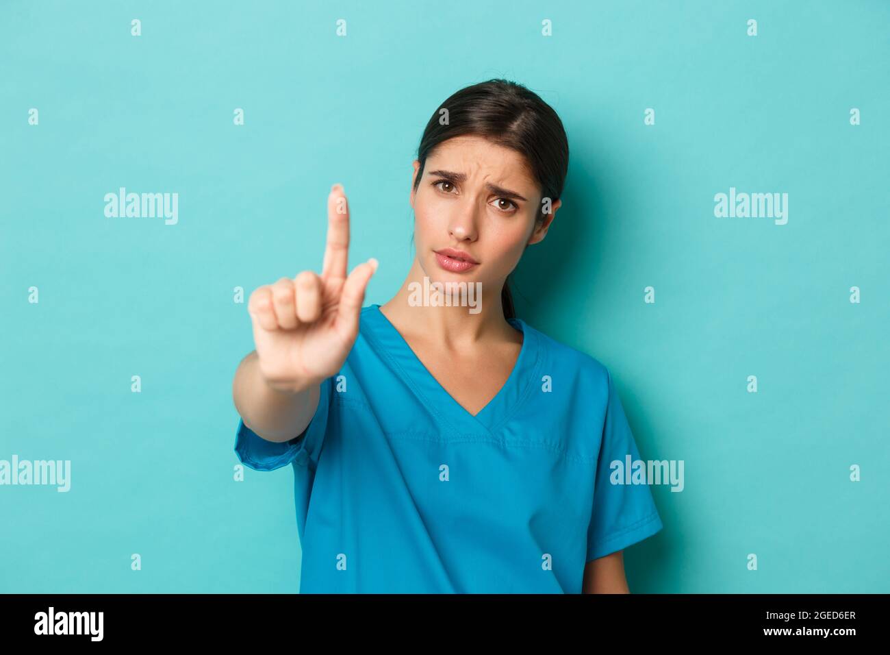 Coronavirus, soziale Distanzierung und Gesundheitskonzept. Nahaufnahme einer enttäuschten Ärztin, die sagt, sie solle aufhören, den Finger schütteln, um zu verbieten oder nicht zu stimmen Stockfoto