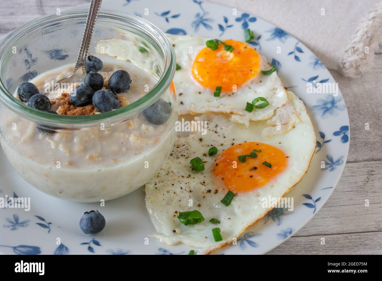 Hausgemachtes Frühstück mit Hafer, Heidelbeeren und Eiern auf dem Teller Stockfoto