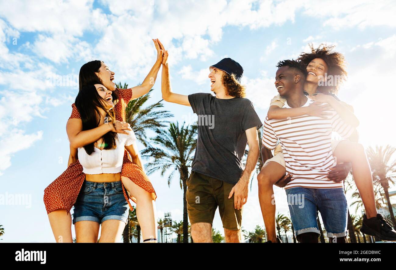 Gruppe von glücklichen multirassischen Freunden, die im Freien mit Rückenlicht feiern Stockfoto