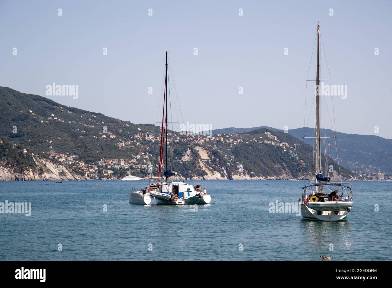 Segelyachten an der Küste. Touristen strömen am 19. August 2021 in die wunderschöne Stadt Santa Margherita im Levante Teil Liguriens. Santa Margherita und Ligurien bestechen durch die schöne Natur mit Meer, Hügeln, wo gewandert und geradelt werden kann und der schönen & bunten Architektur. Am Hafen von Santa Margherita legen viele Boote und Yachten an. * Segelyachten an der Küste. Am 19. August 2021 besuchen Touristen die wunderschöne Santa Marghrita im Levante-Teil von Ligury, Norditalien. Die Menschen lieben Santa Margherita wie Ligury überhaupt wegen der schönen Nature mit den Hügeln / Stockfoto