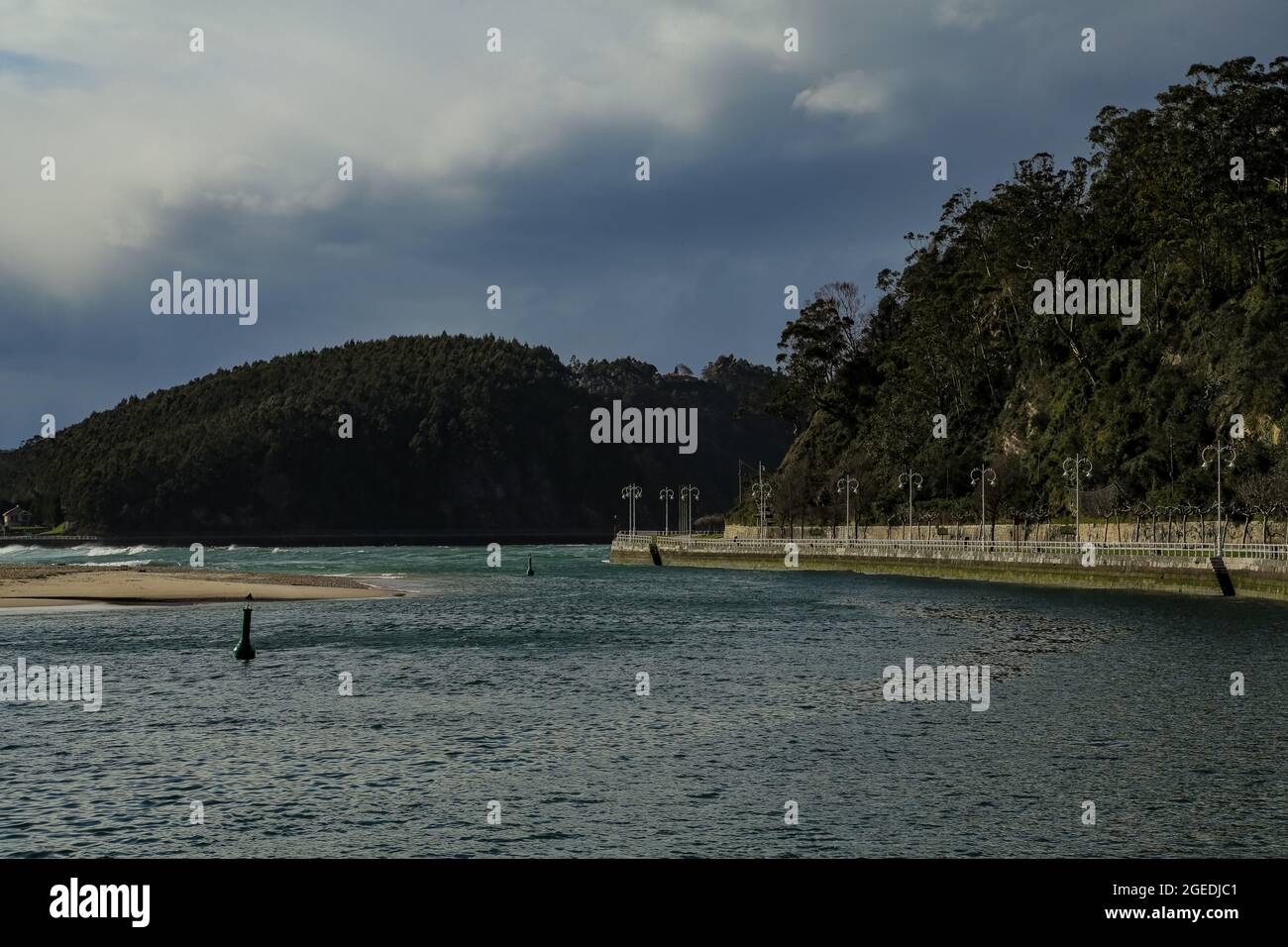 Blick auf das Meer und die Berge mit Wellen, die am Strand und an den Klippen krachen Stockfoto