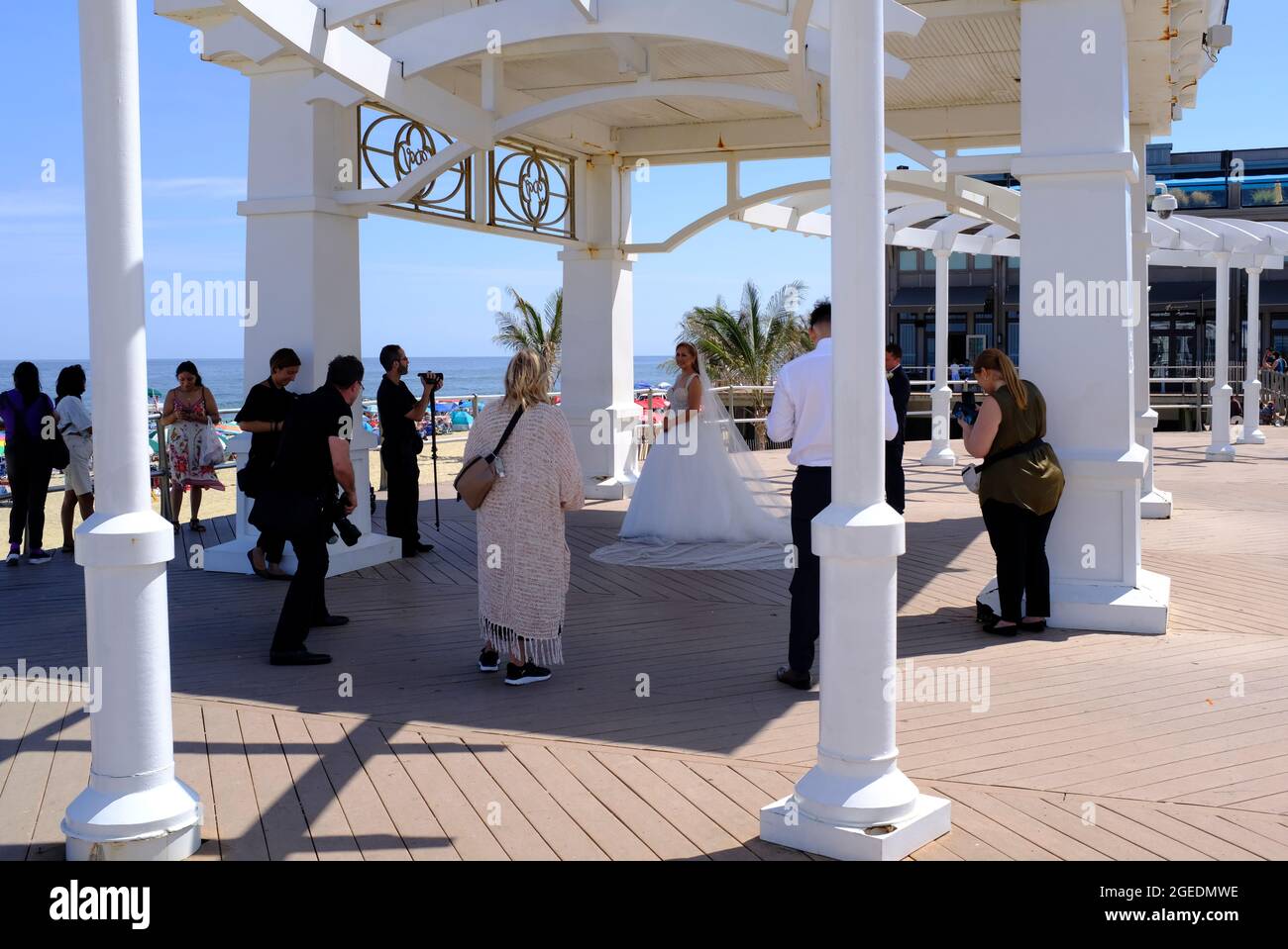 Das frisch verheiratete Paar posiert unter einem Baldachin auf dem Boardwalk in Long Branch, New Jersey Stockfoto