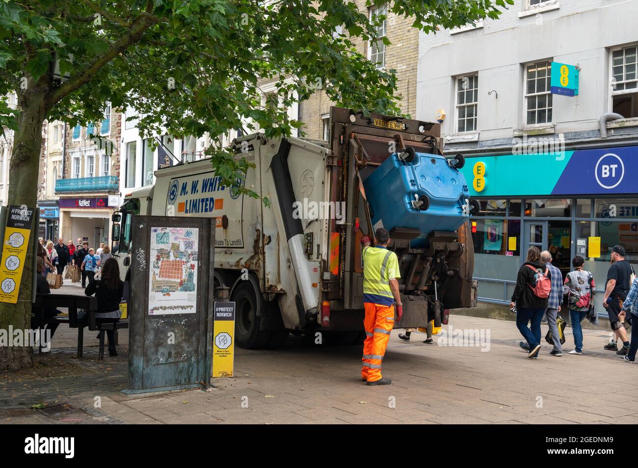 Mülleimer leert an einem geschäftigen Tag einen kommerziellen blauen Papierkorb im Zentrum von Norwich City Stockfoto