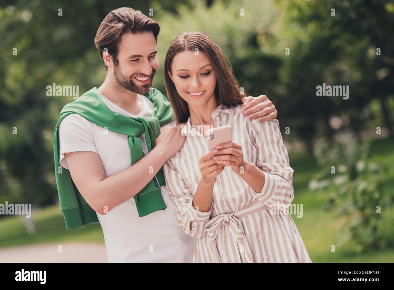 Foto von jungen fröhlichen Paar glücklich positive Lächeln Blick durchsuchen Handy Reise Urlaub Spaziergang im Freien Stockfoto