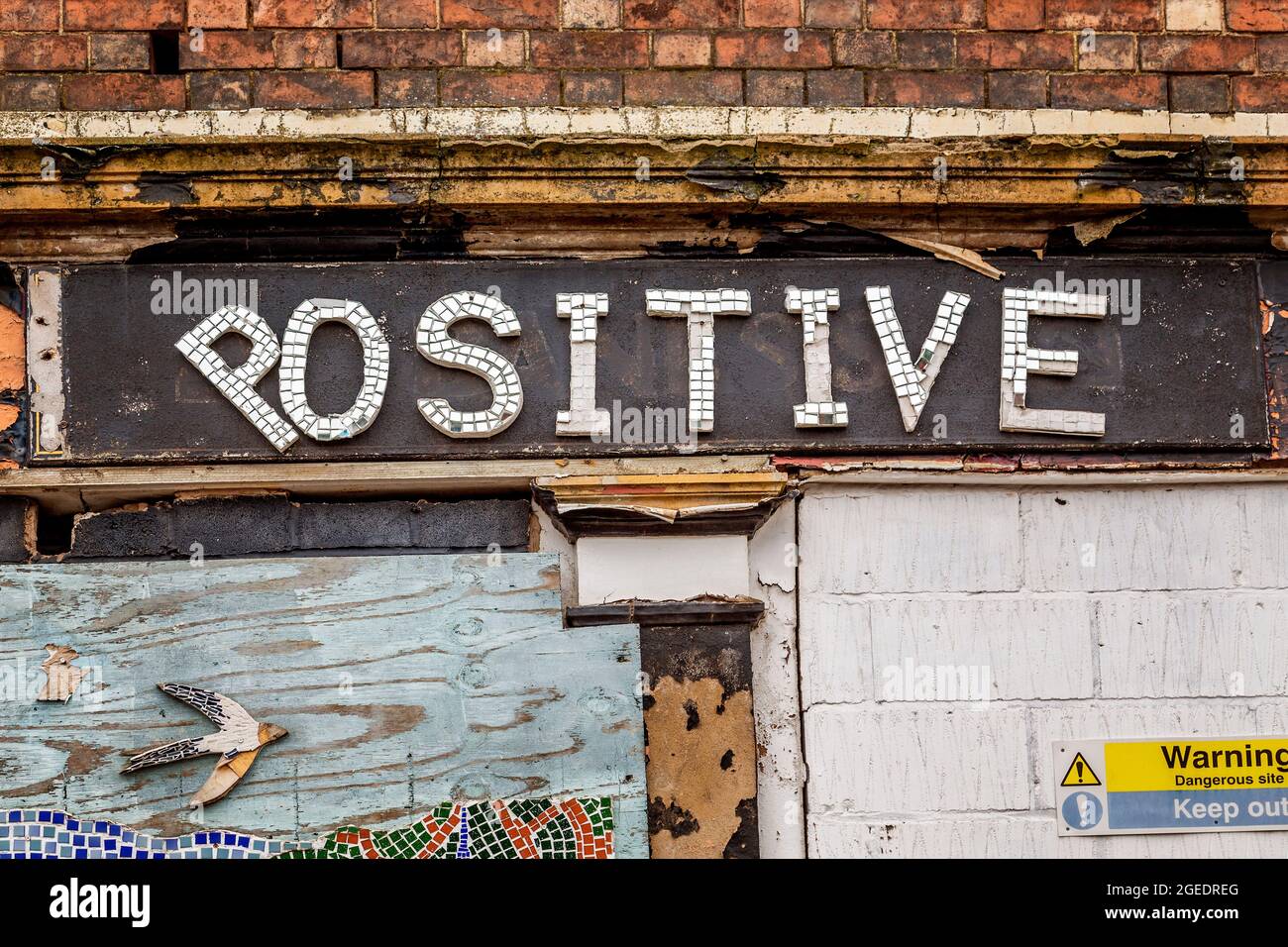 Eine aufgetaufte Ladenfront zeigt ironischerweise das Wort positiv auf der Beschilderung. Stockfoto