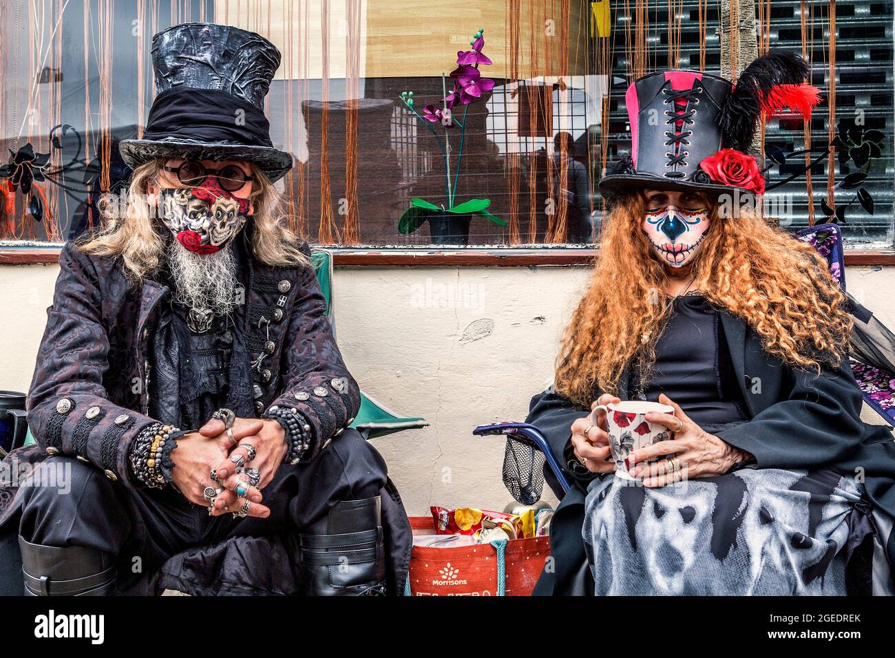 Ein Paar in Dampf-Punk- oder Gothic-Kleidung genießt eine Tasse Tee. Stockfoto