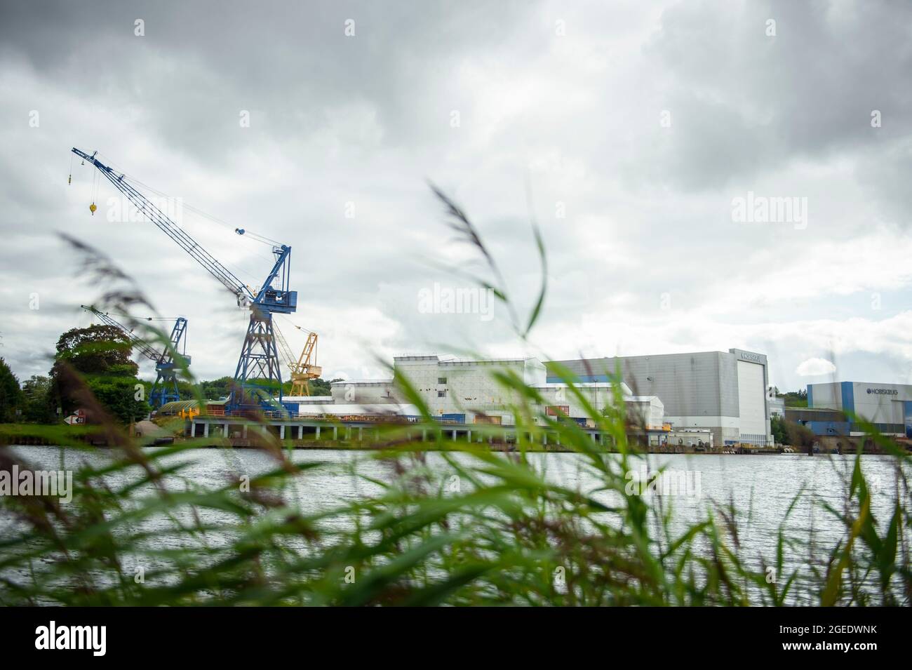 19. August 2021, Schleswig-Holstein, Rendsburg: Eine Fabrikhalle und ein Kran der Nobiskrug-Werft sind von Büdelsdorf aus zu sehen. Die Werft am Nord-Ostsee-Kanal in Rendsburg wurde von der Flensburger Schiffbau-Gesellschaft übernommen. Foto: Gregor Fischer/dpa Stockfoto