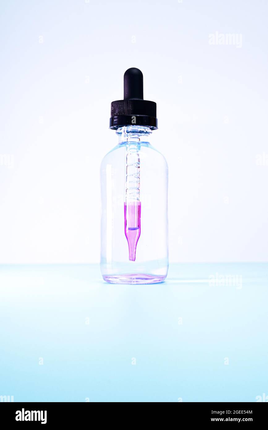 Glasflasche mit violetter Farbe auf weißem Hintergrund Stockfoto