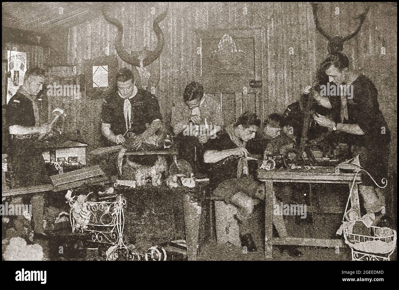 Ein altes Foto aus der Zeitschrift um die 40er Jahre zeigt eine Gruppe britischer Pfadfinder, die zusammengebrochenes Spielzeug reparierten, um es armen Kindern zu geben. Stockfoto
