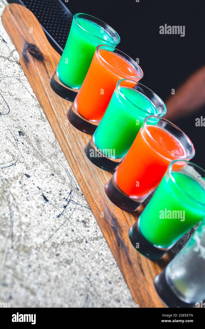 Der Barkeeper bereitet Cocktails zu. Mehrfarbiger Cocktail. Erfrischende Cocktails. regenbogen-Cocktails. regenbogen-Cocktail in Vintage-Gläsern. Cocktails gibt es Stockfoto