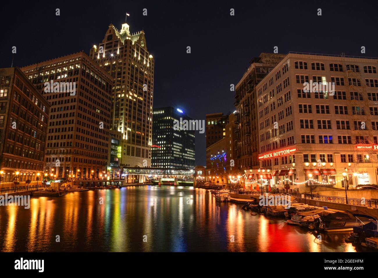 Nachtansicht des Milwaukee Riverwalk, einem Fußgängerweg, der sich entlang des Milwaukee River schlängelt, neben Restaurants, Einkaufsmöglichkeiten, Milwaukee, WI, USA Stockfoto