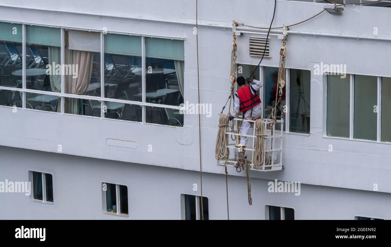 Der Seemann bereitet sich auf die Lackierung außerhalb des Schiffes vor Stockfoto