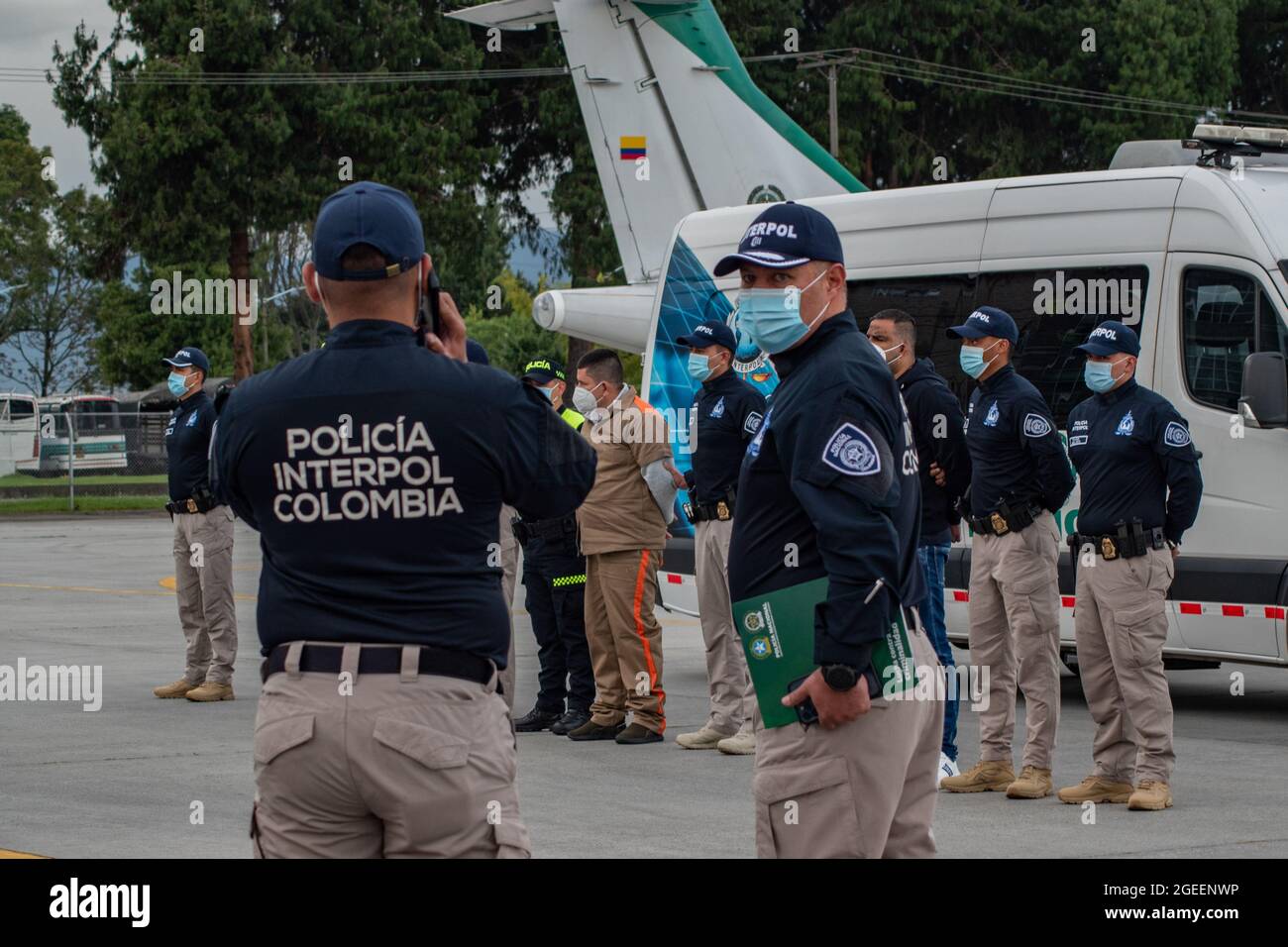 Bogota, Kolumbien. August 2021. Interpol-Polizisten wie Yamit Picon Rodriguez alias 'CHONCHA' Henry Trigos Celon alias 'HENRY' sowohl von der ELN-Guerilla als auch Alexander Montoya Usuga alias 'El Flaco' vom Golfclan 'Clan del Golfo' werden vor ihrer Auslieferung in die Vereinigten Staaten von der Polizei von Interpol und der kolumbianischen Polizei begleitet, Am 19. August 2021 auf dem Militärstützpunkt CATAM in Bogota, Kolumbien. Kredit: Long Visual Press/Alamy Live Nachrichten Stockfoto