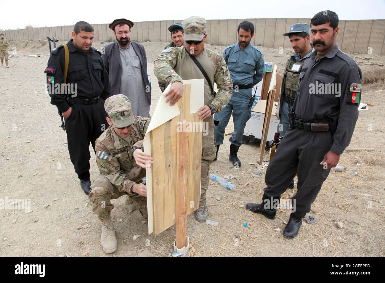 Soldaten der US-Armee, die dem Team 28 der Sicherheitskräfte, der Task Force 3/101, zugewiesen wurden, heften ein Ziel der uniformierten afghanischen Polizei, die der Stadt Khost zugewiesen wurde, um während eines Live-Feuers auf einen kleinen Waffenbereich auf Lager Parsa, Provinz Khowst, Afghanistan, 30. Januar 2013 zu schießen. Die Reichweite ermöglichte es der AUP, ihre Kampfkünste mit M-9 Beretta Pistolen und AK-47 Gewehren zu üben. (USA Armeefoto von Sgt. Kimberly Trumbull / Veröffentlicht) Stockfoto