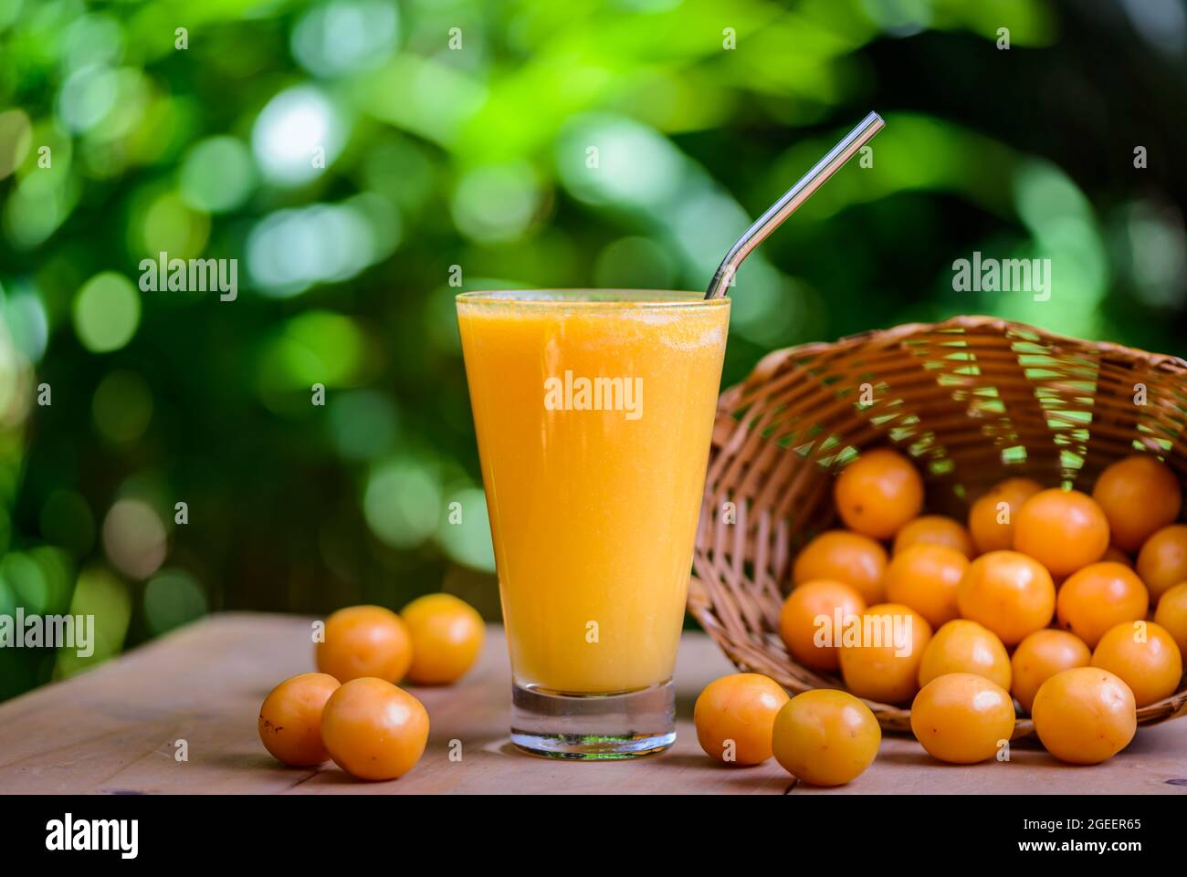 Brasilianischer obstkaja. Ein Glas Saft auf einem Holztisch. Stockfoto