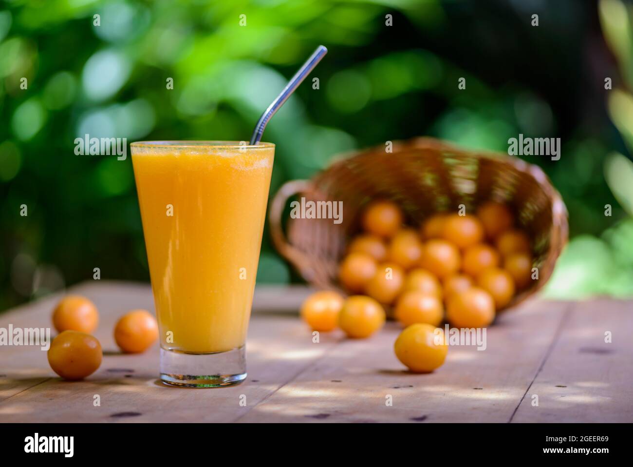 Brasilianischer obstkaja. Ein Glas Saft auf einem Holztisch. Stockfoto