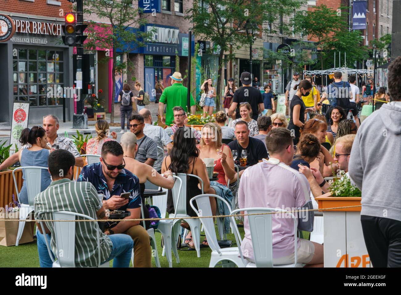Montreal, CA - 17. Juli 2021: Menschen essen auf Restaurantterrassen auf der Mont-Royal Avenue Stockfoto