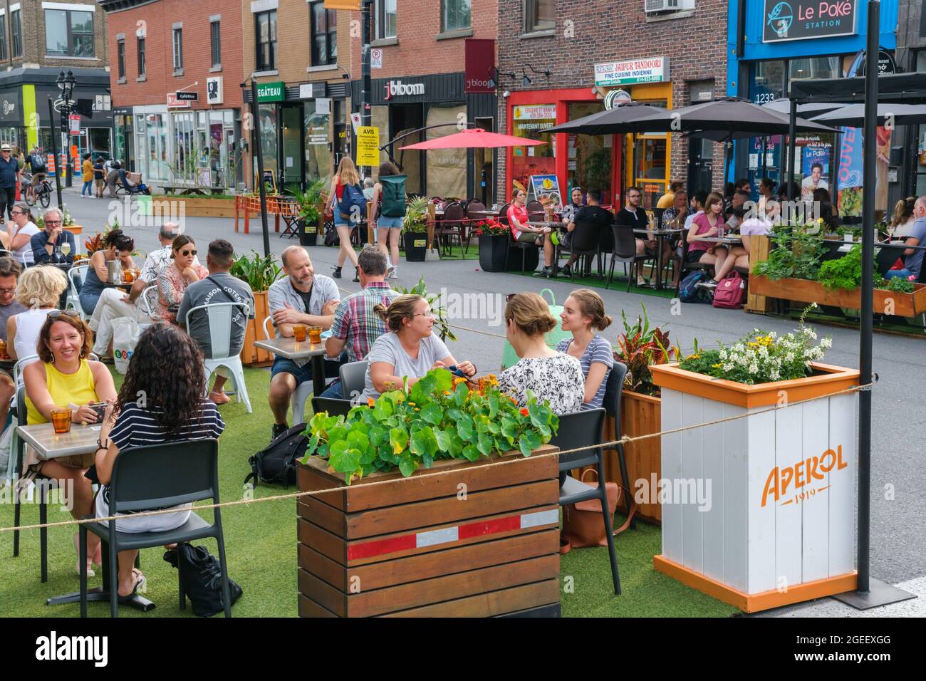 Montreal, CA - 17. Juli 2021: Menschen essen auf Restaurantterrassen auf der Mont-Royal Avenue Stockfoto