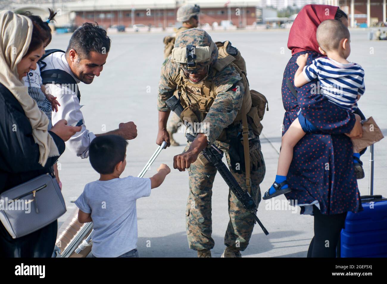 210818-M-JM820-1182 HAMID KARZAI INTERNATIONAL AIRPORT, Afghanistan (18. August 2021) – EINE US-Marine, die der 24. Marine Expeditionary Unit zugeordnet ist, faut einen Kinderevakuierten während eines militärischen Abzugs am Hamid Karzai International Airport, Afghanistan, am 18. August. US-Dienstmitglieder unterstützen das Außenministerium bei einer geordneten Abseichung von designiertem Personal in Afghanistan. (USA Marine Corps Foto von Lance CPL. Nichola Guevara) Stockfoto