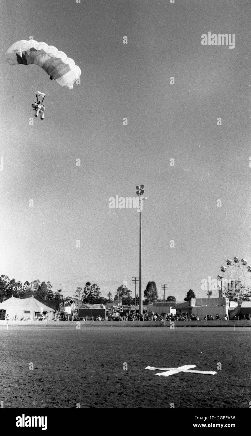 GATTON QUEENSLAND, AUSTRALIEN, JULI 1984: Ein Fallschirmspringer springt bei der jährlichen A- und P-Show in Gatton, Queensland, 1984 in den Showring. Gescannt von Originalnegativen für die Zeitungsveröffentlichung. Stockfoto