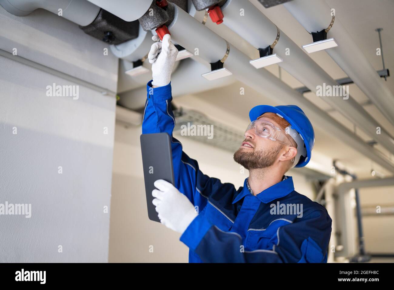 Inspektion der PVC-Wasserleitung durch den Bauarbeiter Stockfoto