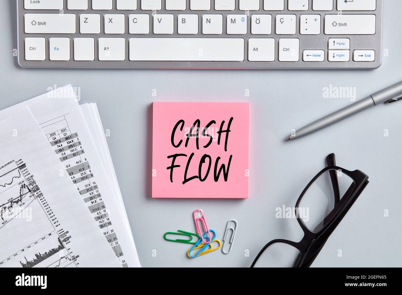 Das Wort Cashflow auf rosa Notizpapier auf dem Desktop des Büroarbeitspitzes. Business Finance-Konzept. Stockfoto