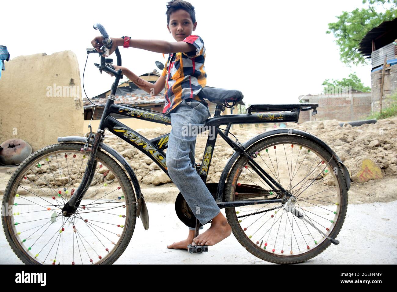 Das indische ländliche Kind ist mit seinem Fahrrad glückselig Stockfoto