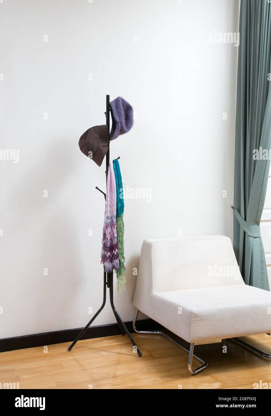 Garderobe aus Metall mit Schals und Hüten im Wohnzimmer Stockfoto