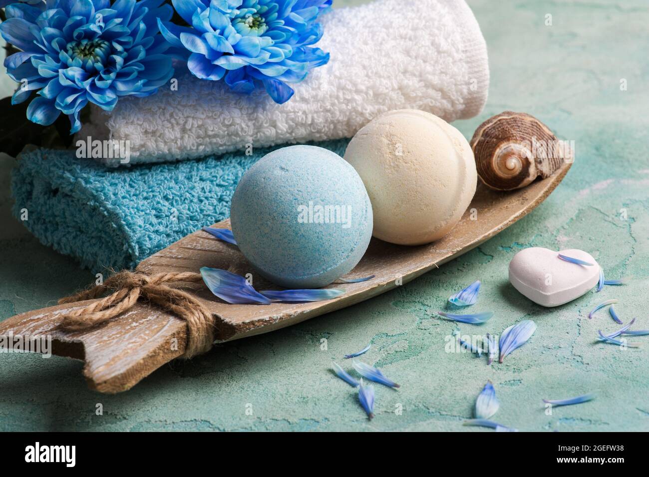 SPA-Behandlung. Blaue Blumen und Badebomben auf Betongrund. Stockfoto