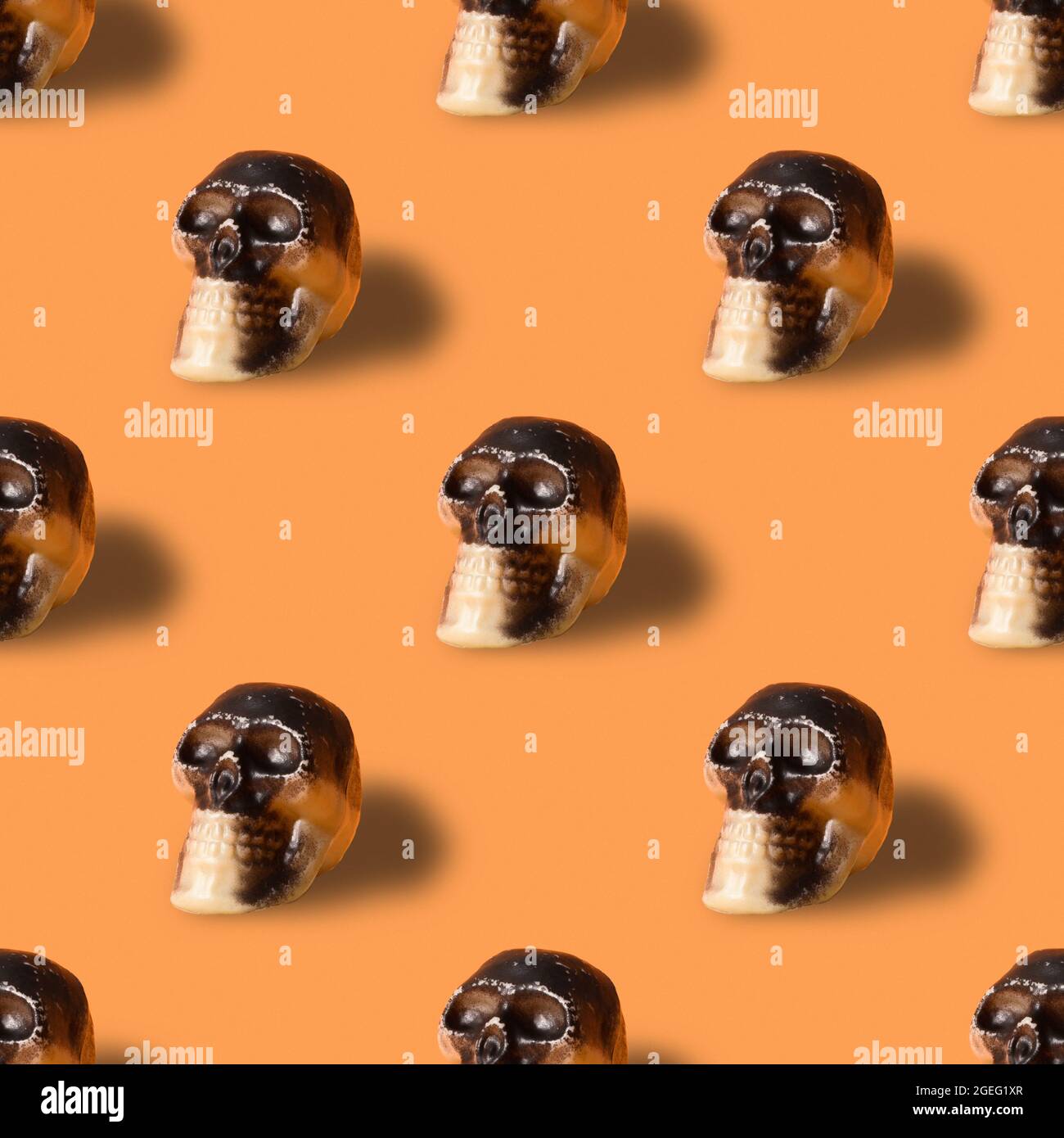 Halloween nahtloses Muster des Schädels auf orangefarbenem Hintergrund. Isometrischer Stil. Minimal Stockfoto