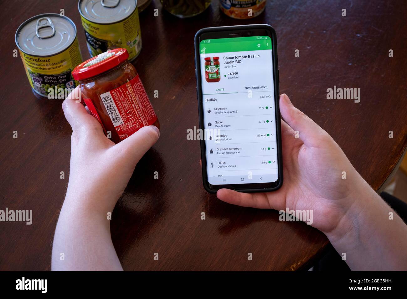 Jemand, der ein Lebensmitteletikett mit einem Smartphone scannt. Kostenlose mobile App, mit der Sie die Barcodes von Lebensmitteln und Körperpflegeprodukten sofort scannen können Stockfoto