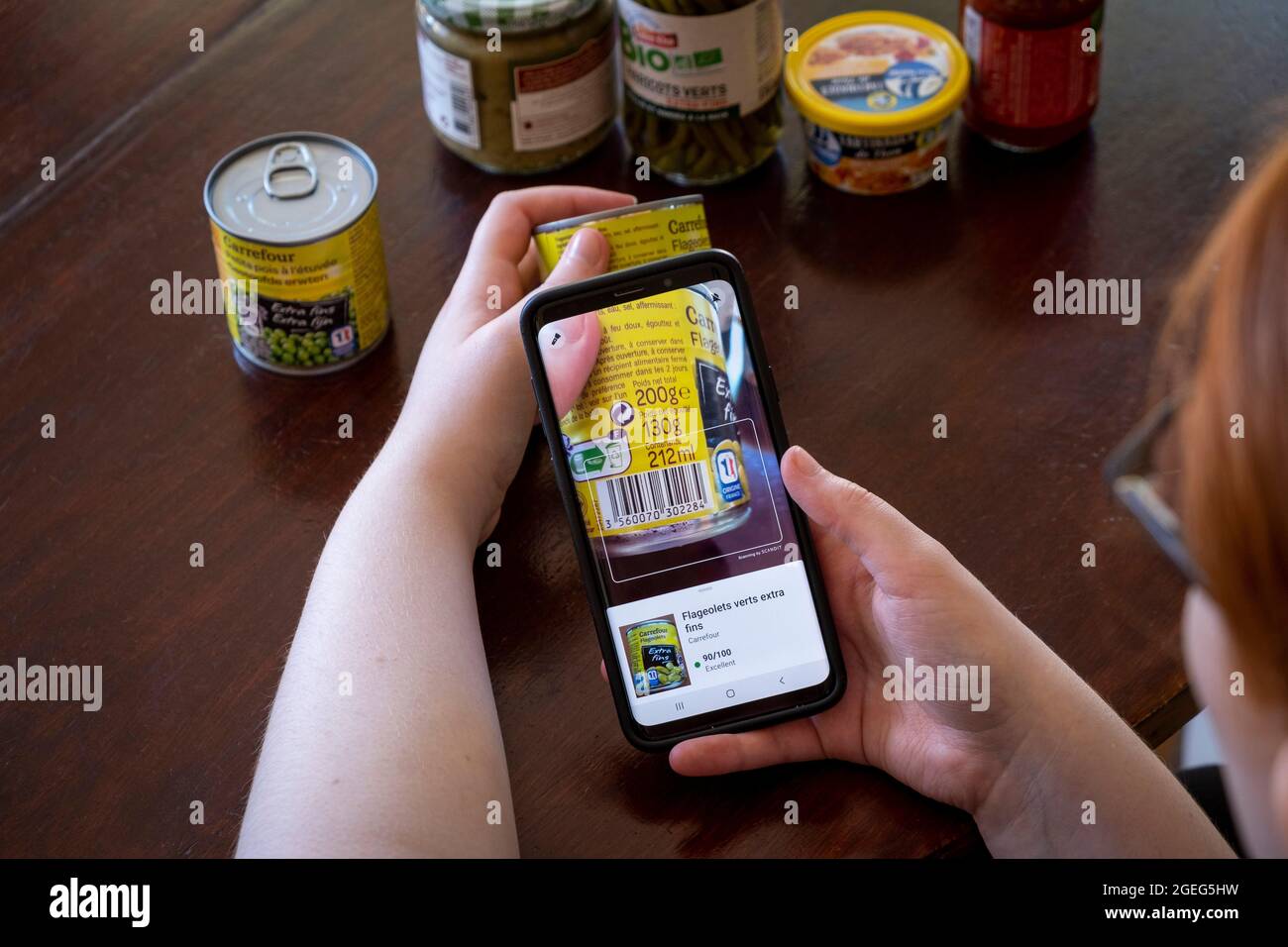 Jemand, der ein Lebensmitteletikett mit einem Smartphone scannt. Kostenlose mobile App, mit der Sie die Barcodes von Lebensmitteln und Körperpflegeprodukten sofort scannen können Stockfoto