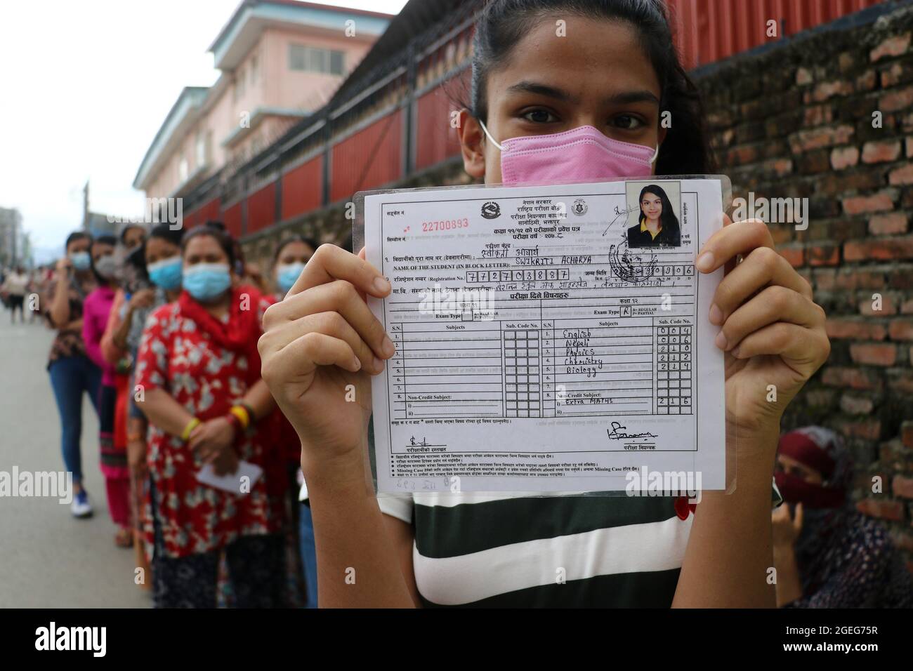 Kathmandu, NE, Nepal. August 2021. Eine Studentin zeigt ihren Prüfungsausweis, während sie in einer Schlange steht, um die erste Dosis des chinesischen Vero Cell Covid-19-Impfstoffs in Kathmandu, Nepal, zu erhalten, 20. August 2021. (Bild: © Aryan Dhimal/ZUMA Press Wire) Stockfoto