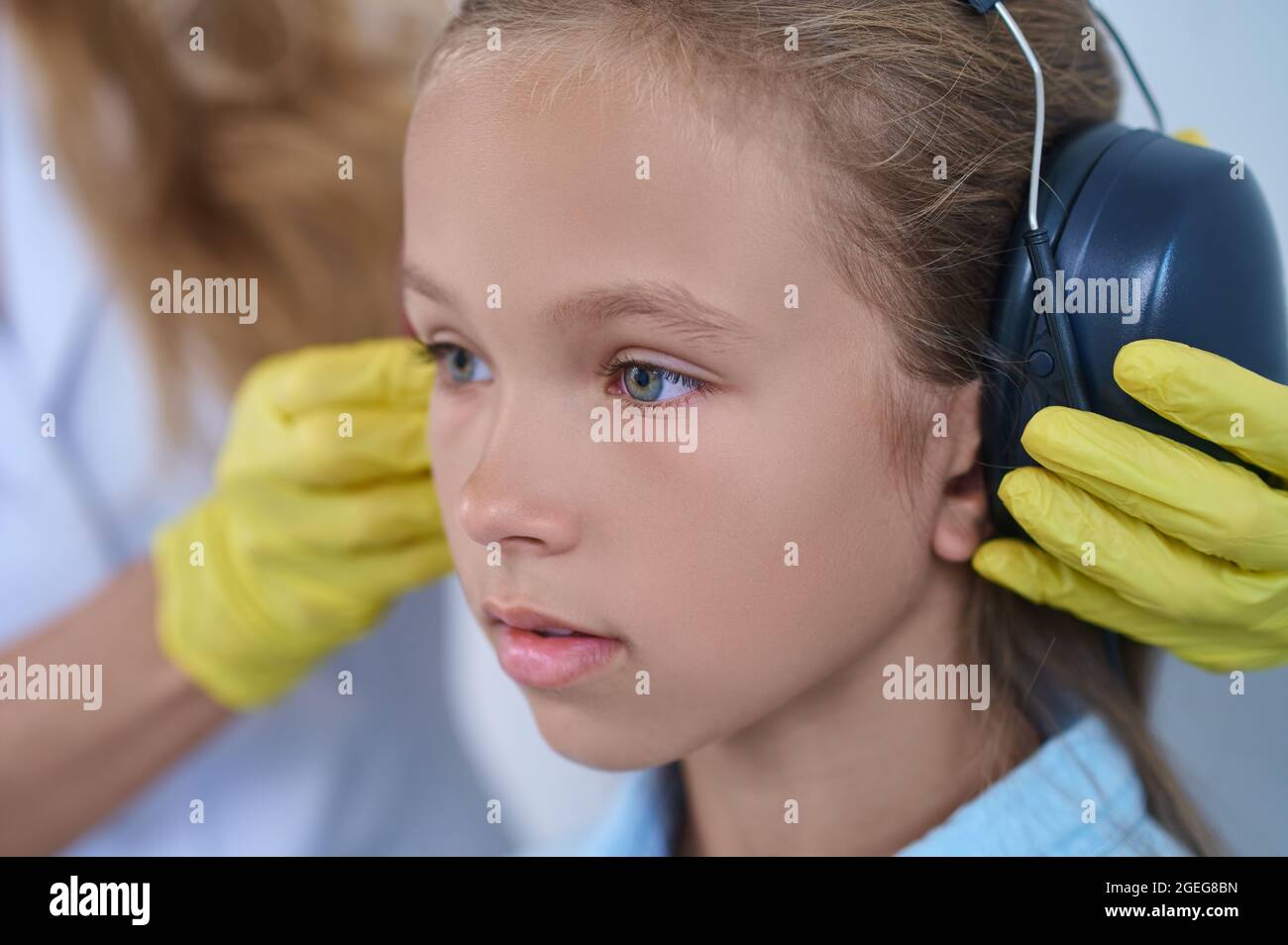 Nahaufnahme der Hände von Mädchen und Ärzten, die Kopfhörer aufsetzen Stockfoto