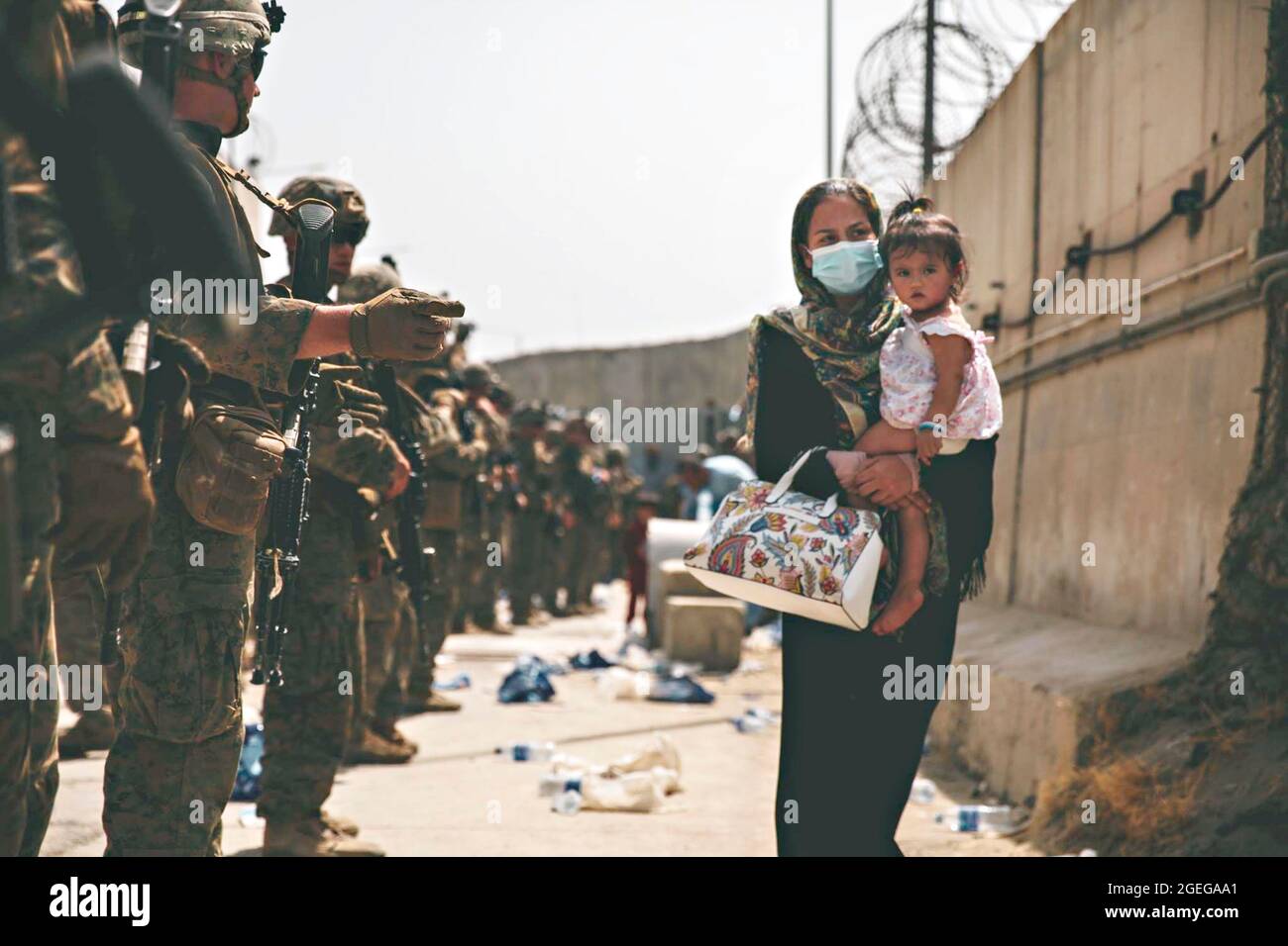 Kabul, Afghanistan. August 2021. US-Marineinfanteristen, die der 24. Marine Expeditionary Unit zugewiesen wurden, begleiten einen Zivilisten zur Evakuierung am Hamid Karzai International Airport im Rahmen der Operation Allies Refuge am 18. August 2021 in Kabul, Afghanistan. Quelle: Planetpix/Alamy Live News Stockfoto