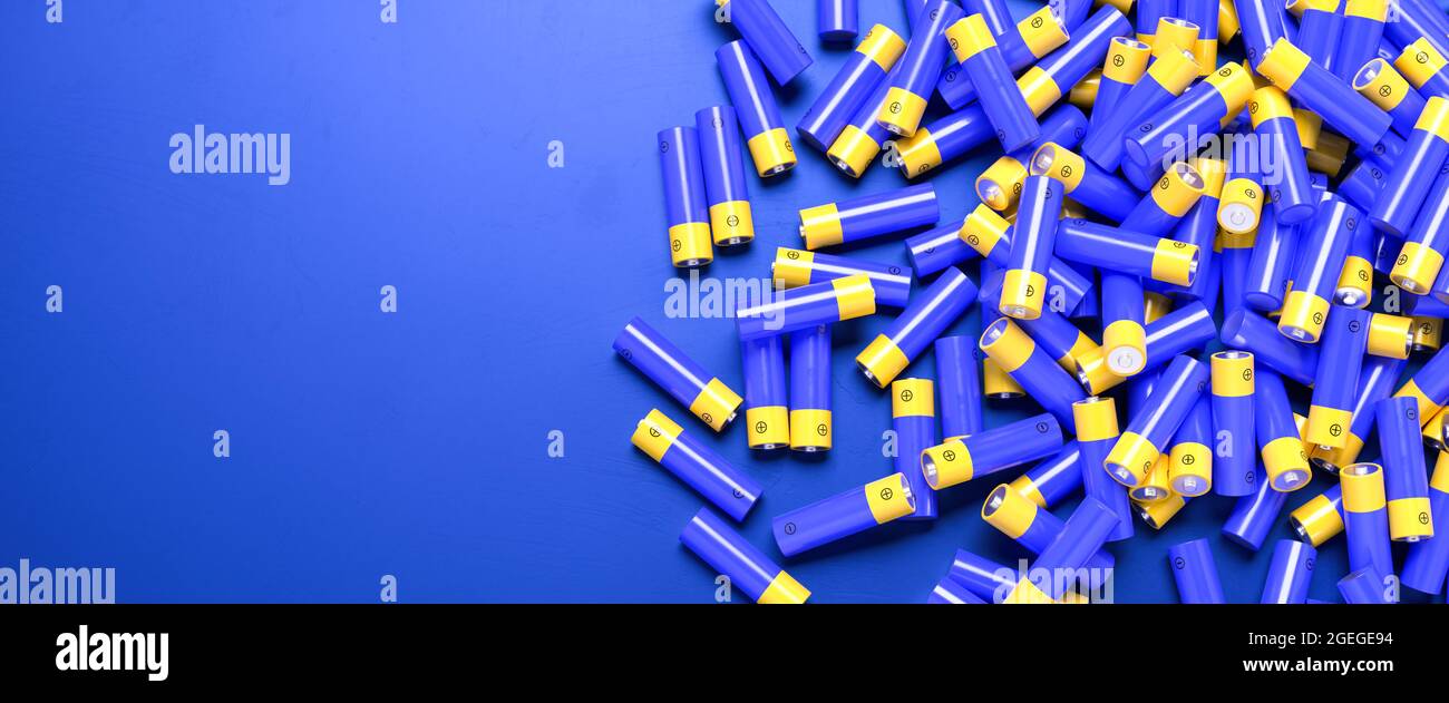 Mehrere AA-Batterien auf blauer Oberfläche. Geringe Schärfentiefe. Webbanner-Format mit Kopierbereich Stockfoto